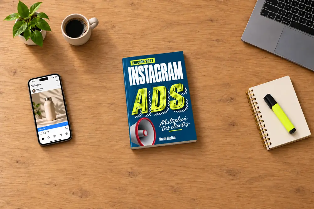 Vista cenital del libro Instagram Ads, junto a un celular con un anuncio, una libreta y un marcador lima sobre una mesa de madera, con la marca Norte Digital.
